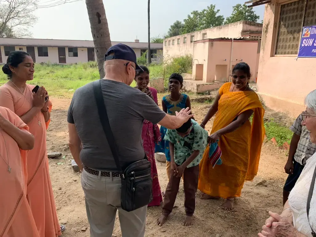 The president of the association greets a child from the village of Kanji with his parents